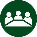 green icon bubble with three people sitting at a desk