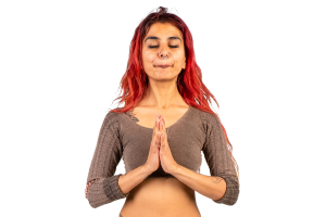 person looking peaceful with eyes closed and hand in a prayer position