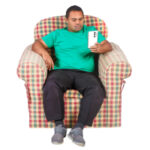 man sitting in armchair reading information on his mobile phone