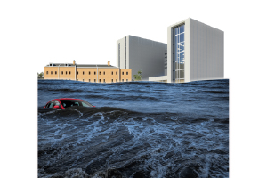 A red car is partially submerged in floodwaters in front of modern buildings.